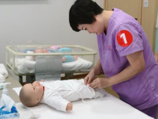 护理师在展现日常宝宝穿衣技巧